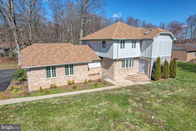 rear view of house with a lawn and a sunroom