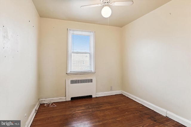 spare room featuring radiator, ceiling fan, and dark wood-type flooring