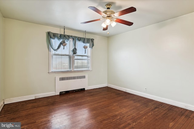 spare room featuring ceiling fan, radiator heating unit, and dark wood-type flooring