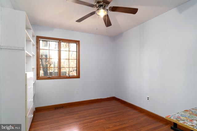 empty room featuring dark hardwood / wood-style flooring and ceiling fan