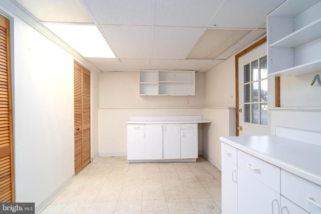 kitchen with a drop ceiling and white cabinets