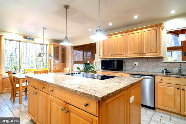 kitchen featuring light stone countertops, a center island, hanging light fixtures, decorative backsplash, and black appliances