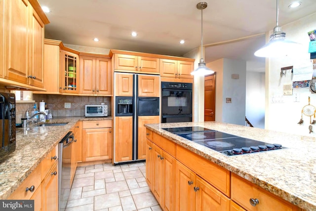 kitchen featuring light stone countertops, backsplash, sink, black appliances, and pendant lighting