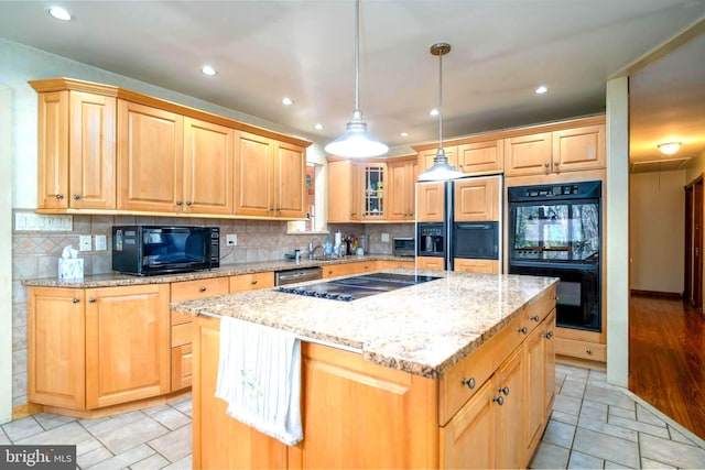 kitchen featuring light stone countertops, decorative backsplash, black appliances, decorative light fixtures, and a kitchen island