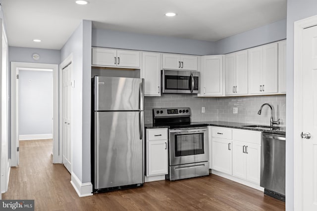 kitchen with dark hardwood / wood-style flooring, sink, white cabinetry, and stainless steel appliances