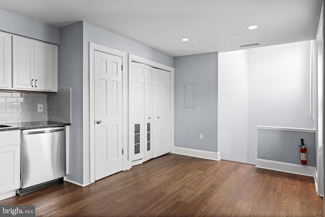 kitchen with backsplash, dark hardwood / wood-style flooring, white cabinets, and stainless steel dishwasher