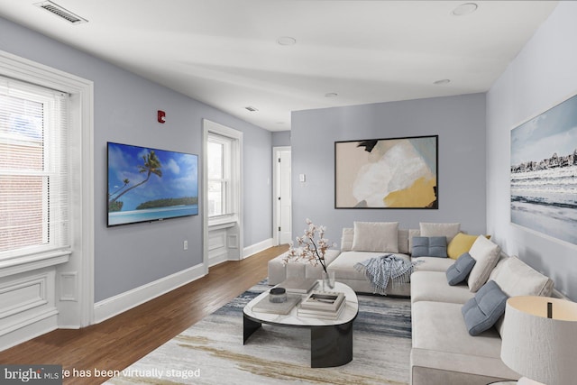 living room featuring plenty of natural light and dark hardwood / wood-style flooring