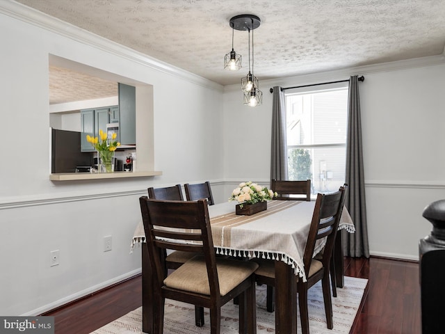 dining room with a textured ceiling, ornamental molding, and dark hardwood / wood-style floors