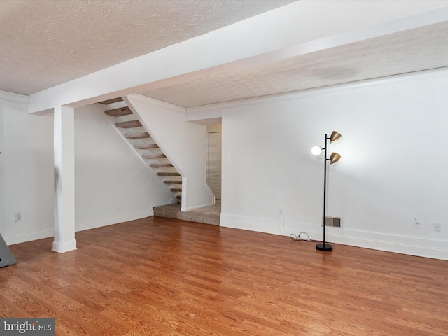 basement with a textured ceiling and wood-type flooring