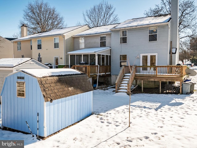 snow covered house with a wooden deck