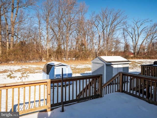 snow covered deck featuring a storage shed