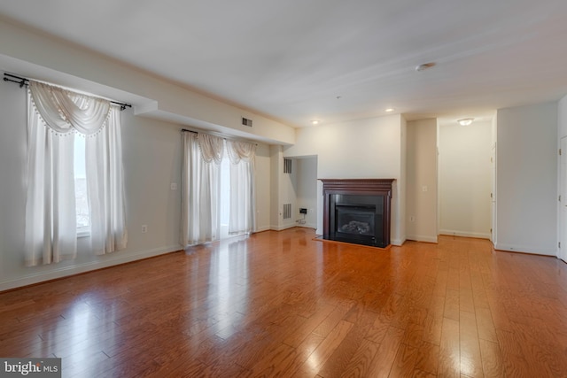 10205 Wincopin Cir Unit 405, Columbia, MD 21044 - unfurnished living room featuring wood finished floors, a glass covered fireplace, and recessed lighting