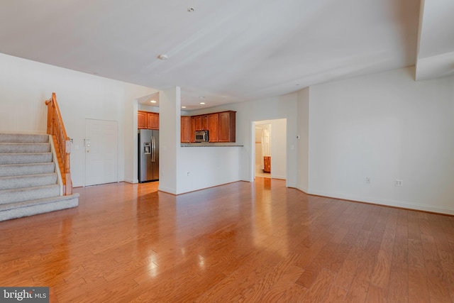 10205 Wincopin Cir Unit 405, Columbia, MD 21044 - unfurnished living room with light wood-type flooring, stairs, and recessed lighting
