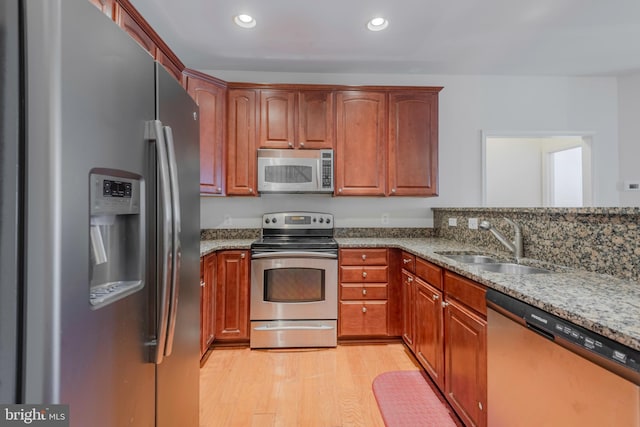 10205 Wincopin Cir Unit 405, Columbia, MD 21044 - kitchen with stainless steel appliances, light stone countertops, light wood-style floors, recessed lighting, and brown cabinets