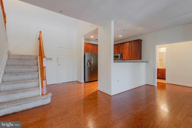 10205 Wincopin Cir Unit 405, Columbia, MD 21044 - unfurnished living room featuring wood finished floors, stairway, and recessed lighting