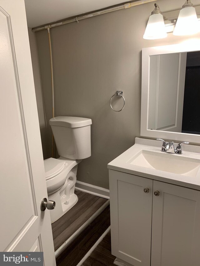 bathroom with vanity, hardwood / wood-style flooring, and toilet