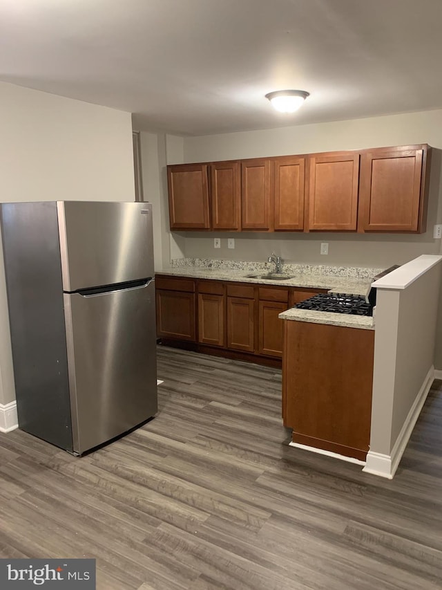 kitchen featuring stainless steel fridge, dark hardwood / wood-style flooring, and sink