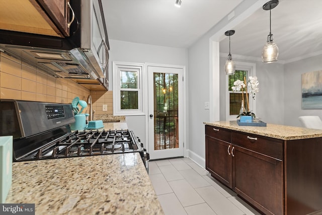 kitchen featuring black range with gas stovetop, hanging light fixtures, decorative backsplash, light stone countertops, and ornamental molding