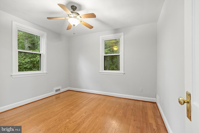 spare room with light hardwood / wood-style flooring, a wealth of natural light, and ceiling fan