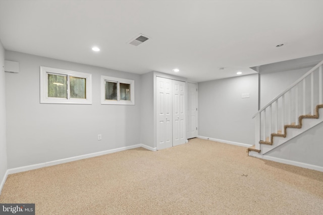 basement with an AC wall unit and carpet floors