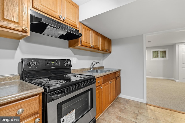 kitchen featuring stainless steel range with electric stovetop, light tile patterned floors, and sink