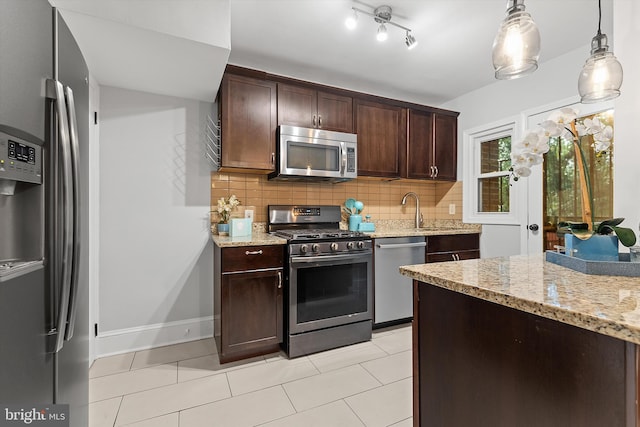 kitchen with sink, hanging light fixtures, tasteful backsplash, light tile patterned floors, and appliances with stainless steel finishes