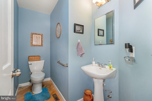 bathroom with toilet and hardwood / wood-style flooring