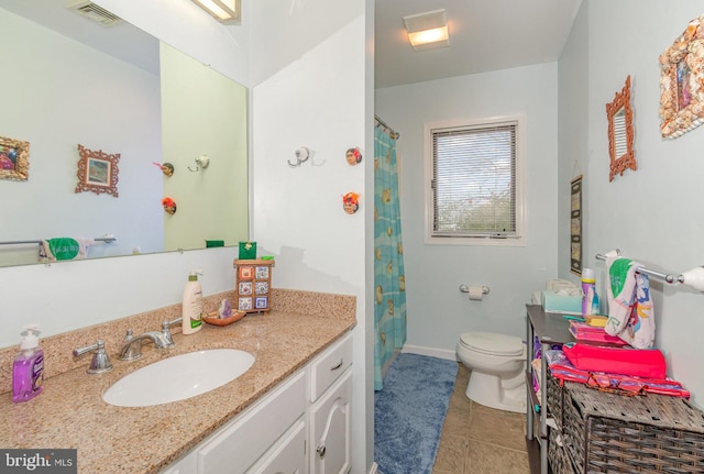 bathroom with tile patterned flooring, vanity, and toilet