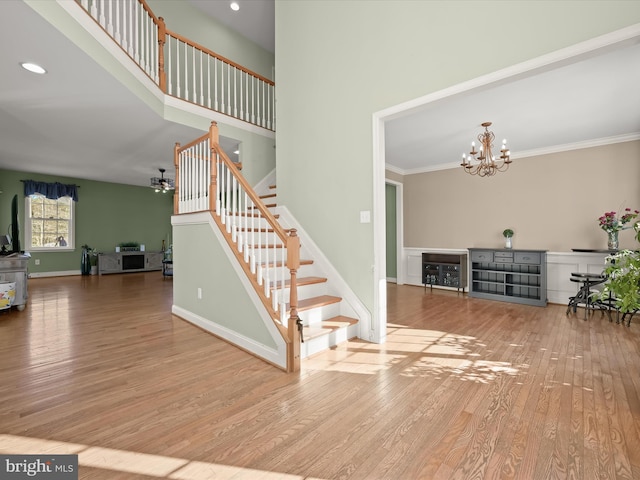 stairs with ornamental molding, a chandelier, and hardwood / wood-style flooring