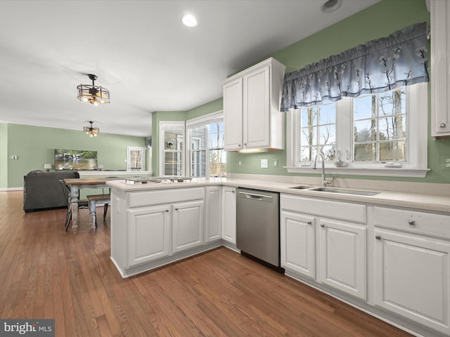 kitchen featuring kitchen peninsula, dark hardwood / wood-style flooring, white cabinetry, appliances with stainless steel finishes, and sink