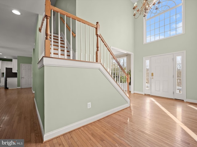 foyer entrance featuring a notable chandelier, a high ceiling, and hardwood / wood-style flooring