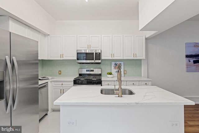 kitchen with white cabinets, a kitchen island, sink, and appliances with stainless steel finishes