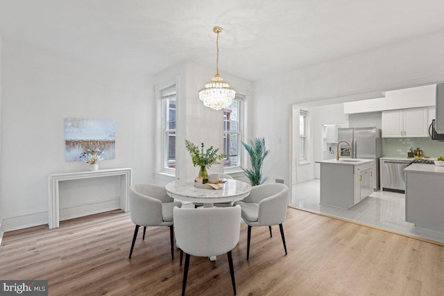 dining room featuring a chandelier, light hardwood / wood-style floors, and sink