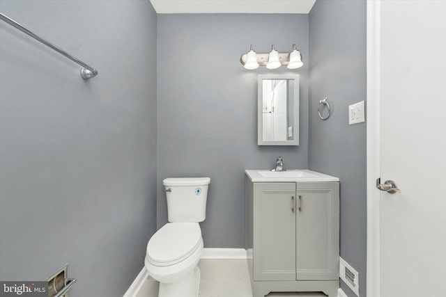 bathroom with toilet, vanity, and tile patterned floors