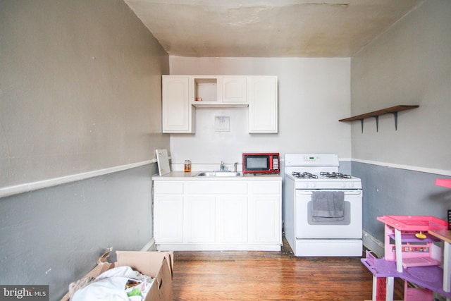 kitchen with white cabinets, dark hardwood / wood-style flooring, white range with gas cooktop, and sink