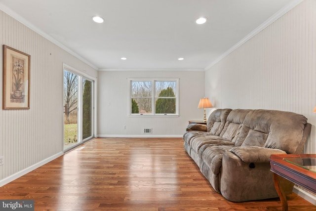 living room with ornamental molding and light hardwood / wood-style floors