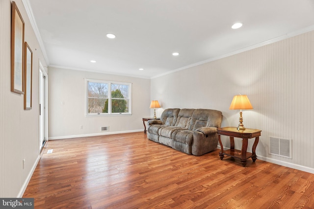 living room with ornamental molding and light hardwood / wood-style floors