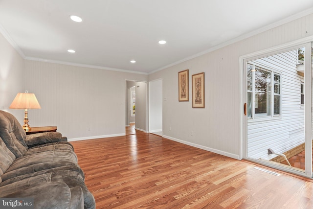 living room with crown molding and light hardwood / wood-style flooring