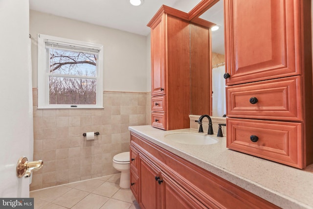 bathroom with tile walls, vanity, tile patterned flooring, and toilet