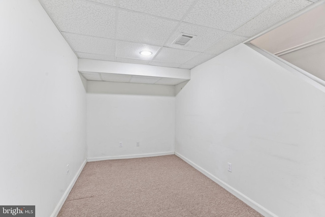 unfurnished room featuring carpet flooring and a drop ceiling