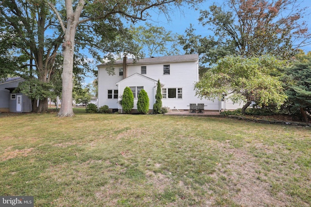 rear view of house with a yard and central AC