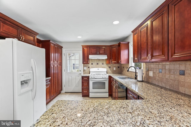 kitchen with tasteful backsplash, sink, white appliances, and light stone countertops