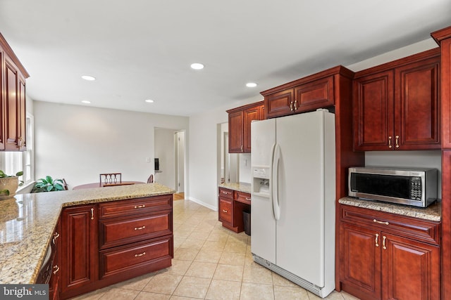 kitchen featuring light stone countertops, light tile patterned floors, and white fridge with ice dispenser