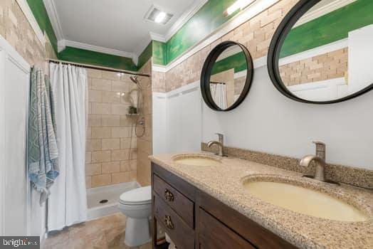 bathroom with crown molding, toilet, vanity, and a shower with shower curtain