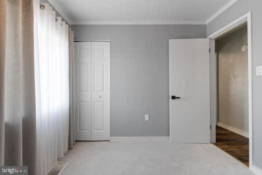 unfurnished bedroom featuring dark wood-type flooring and a closet