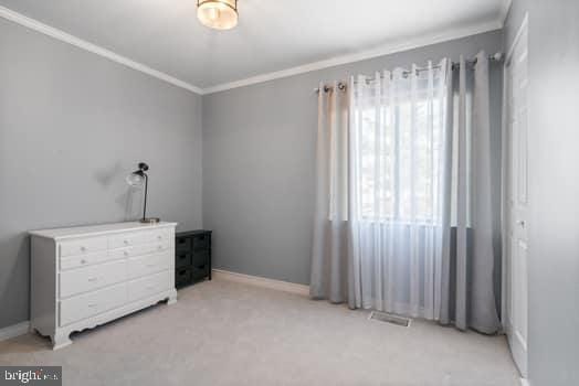 bedroom with light colored carpet and crown molding