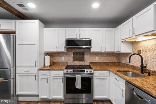 kitchen featuring white cabinets, stainless steel appliances, and sink