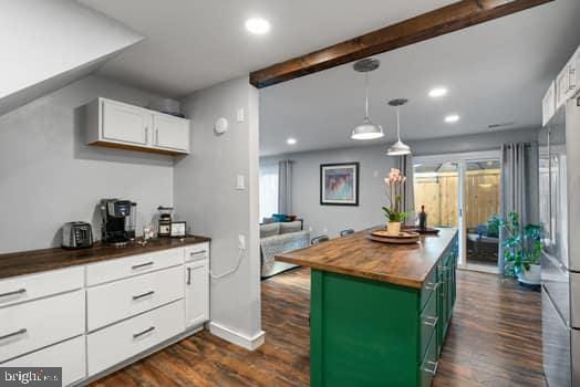 kitchen featuring wood counters, dark wood-type flooring, green cabinetry, a kitchen island, and white cabinetry