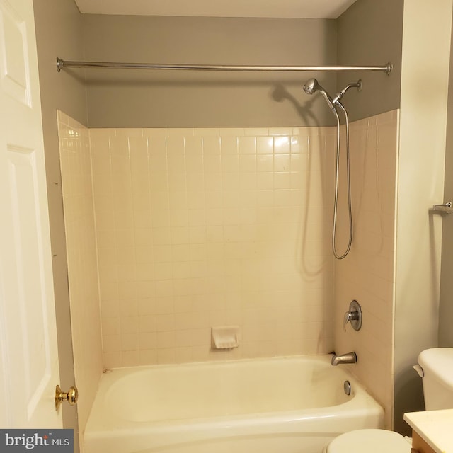 bathroom with toilet and tiled shower / bath