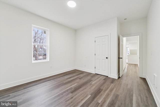 unfurnished bedroom with a closet and hardwood / wood-style flooring